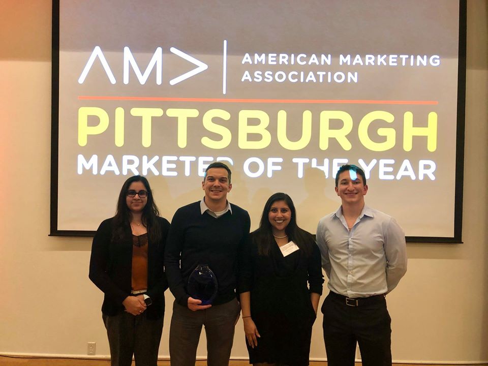 Four staff members and one holding award 